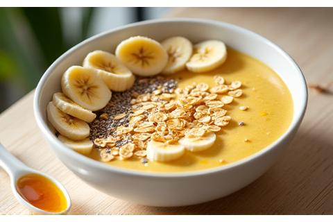 Un smoothie bowl vibrante con plátano rebanado, avena, semillas de chía y un toque de miel.